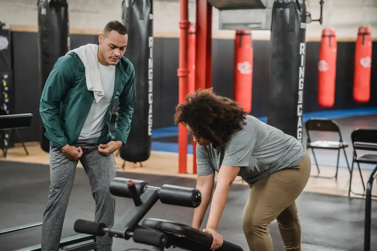 Personal trainer atendendo aluno